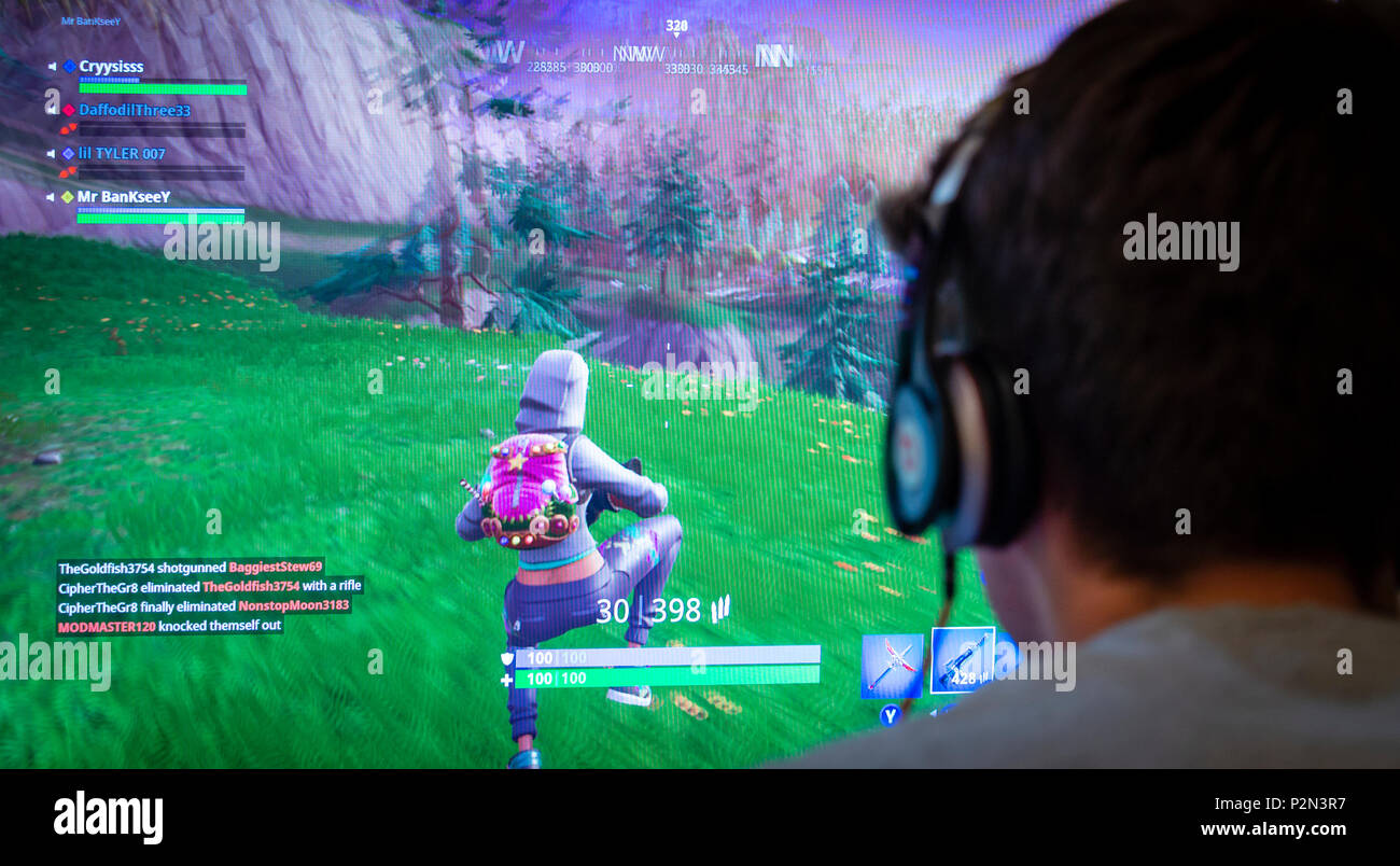 Teenager playing Fortnite video game, Fortnite is an internet-based multiplayer survival game developed by Epic Games. Stock Photo