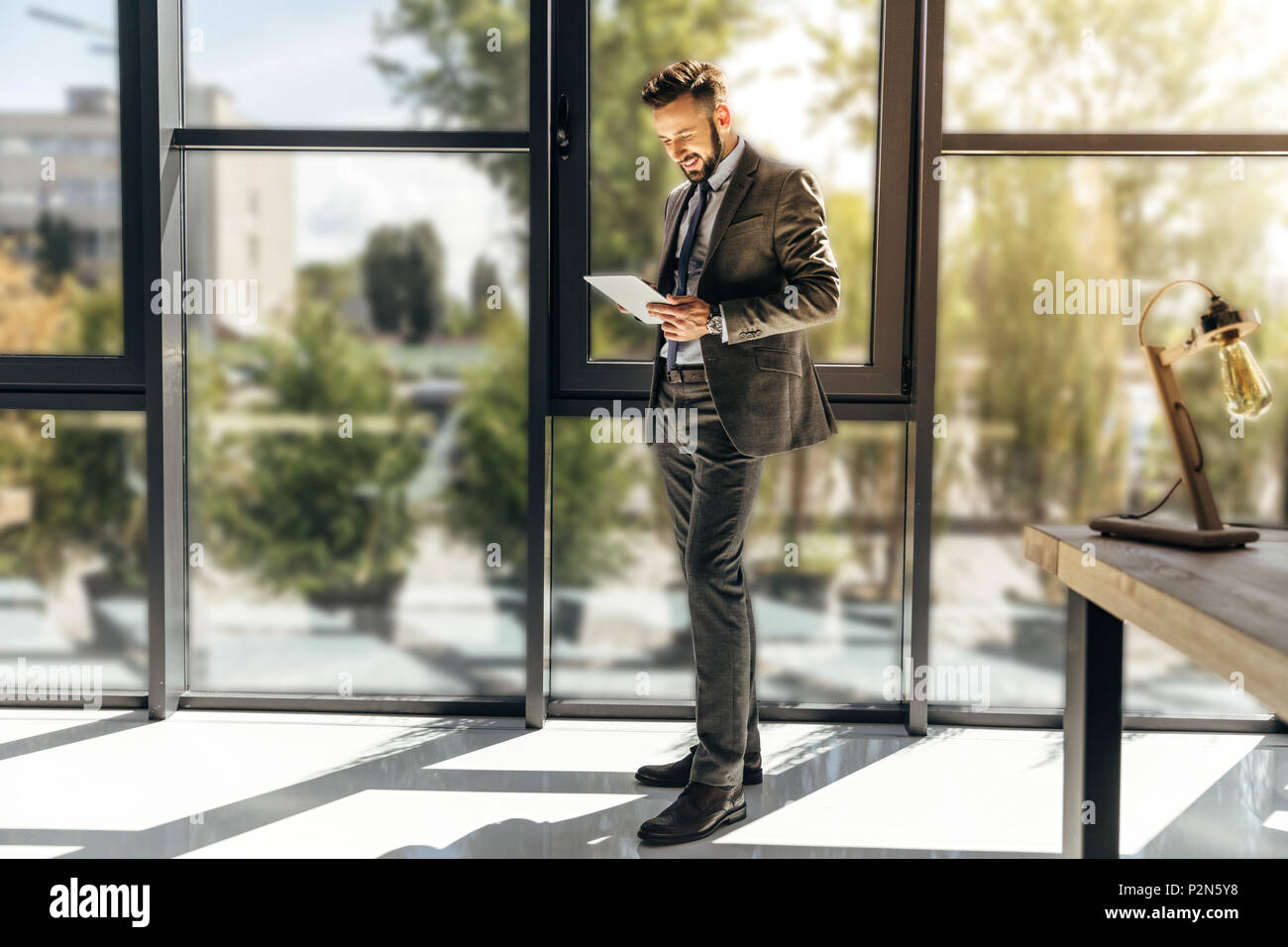 young businessman in suit using digital tablet at modern office Stock ...
