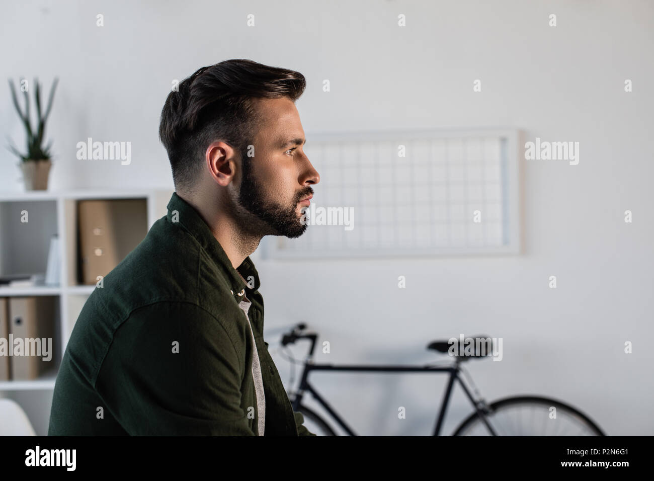 Profile portrait of handsome bearded man looking away in office Stock Photo