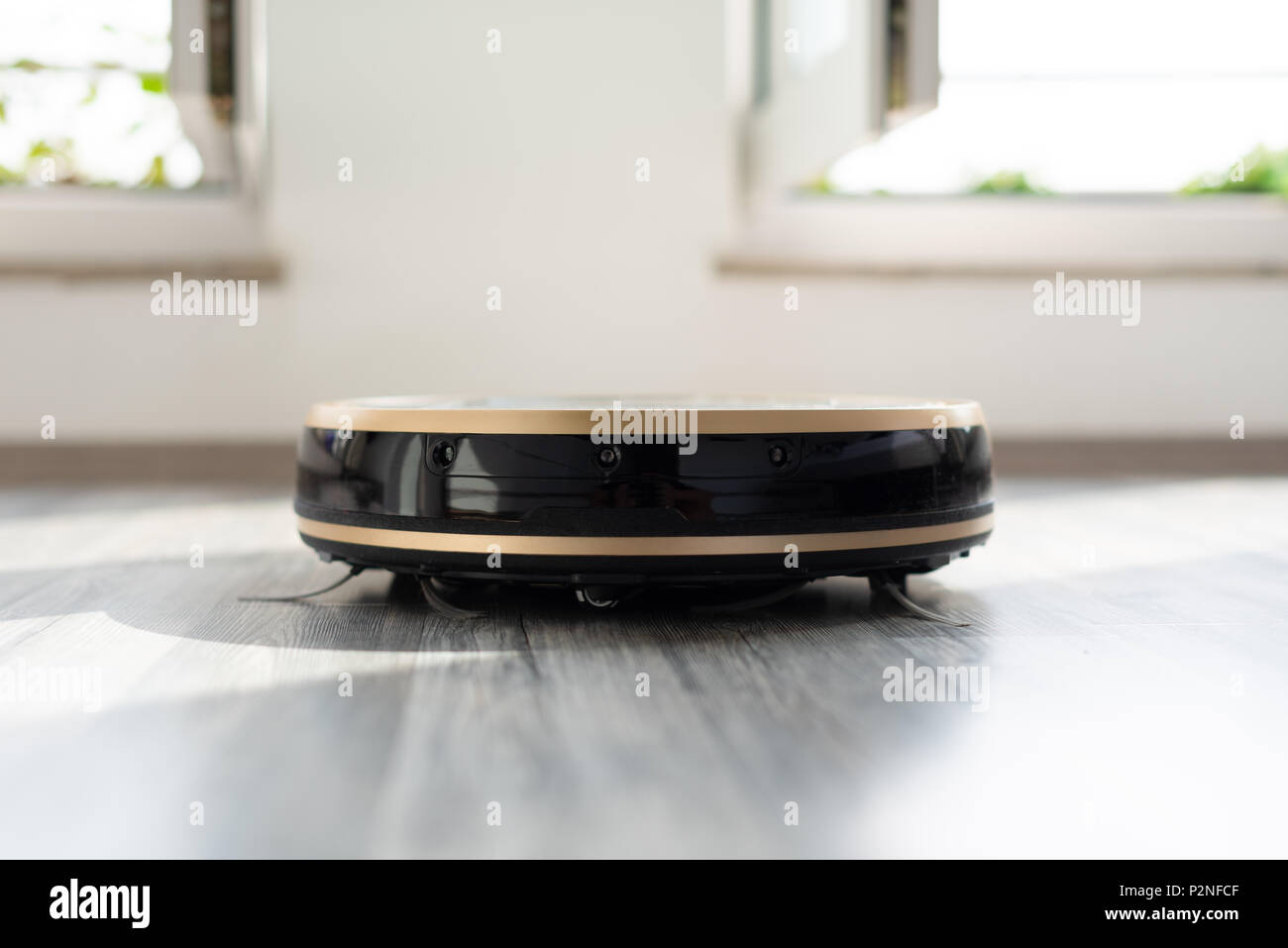 robotic vacuum cleaner on laminate wood floor Stock Photo Alamy