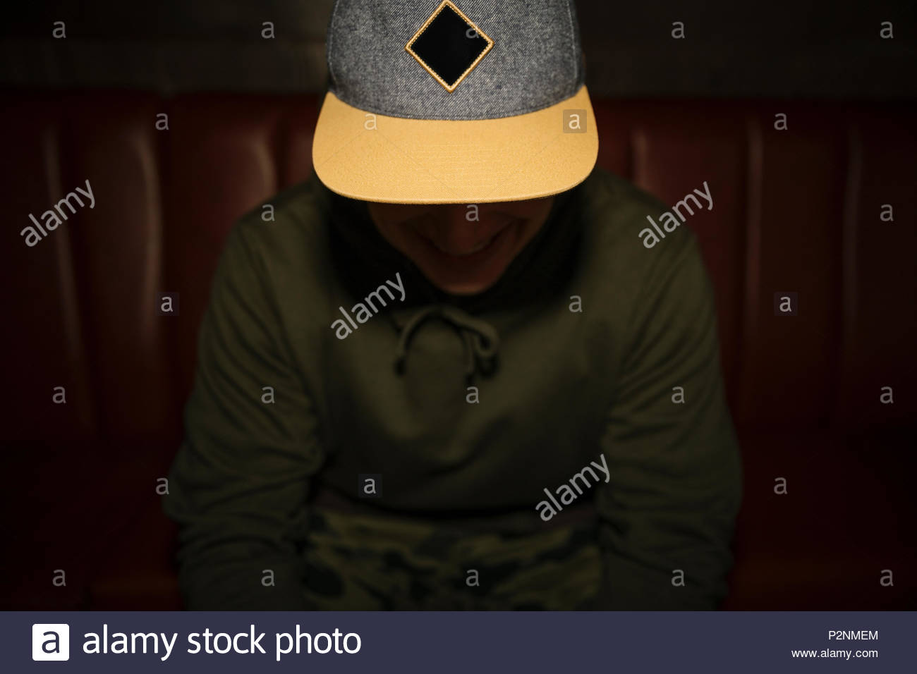 Male millennial in baseball cap looking down Stock Photo Alamy