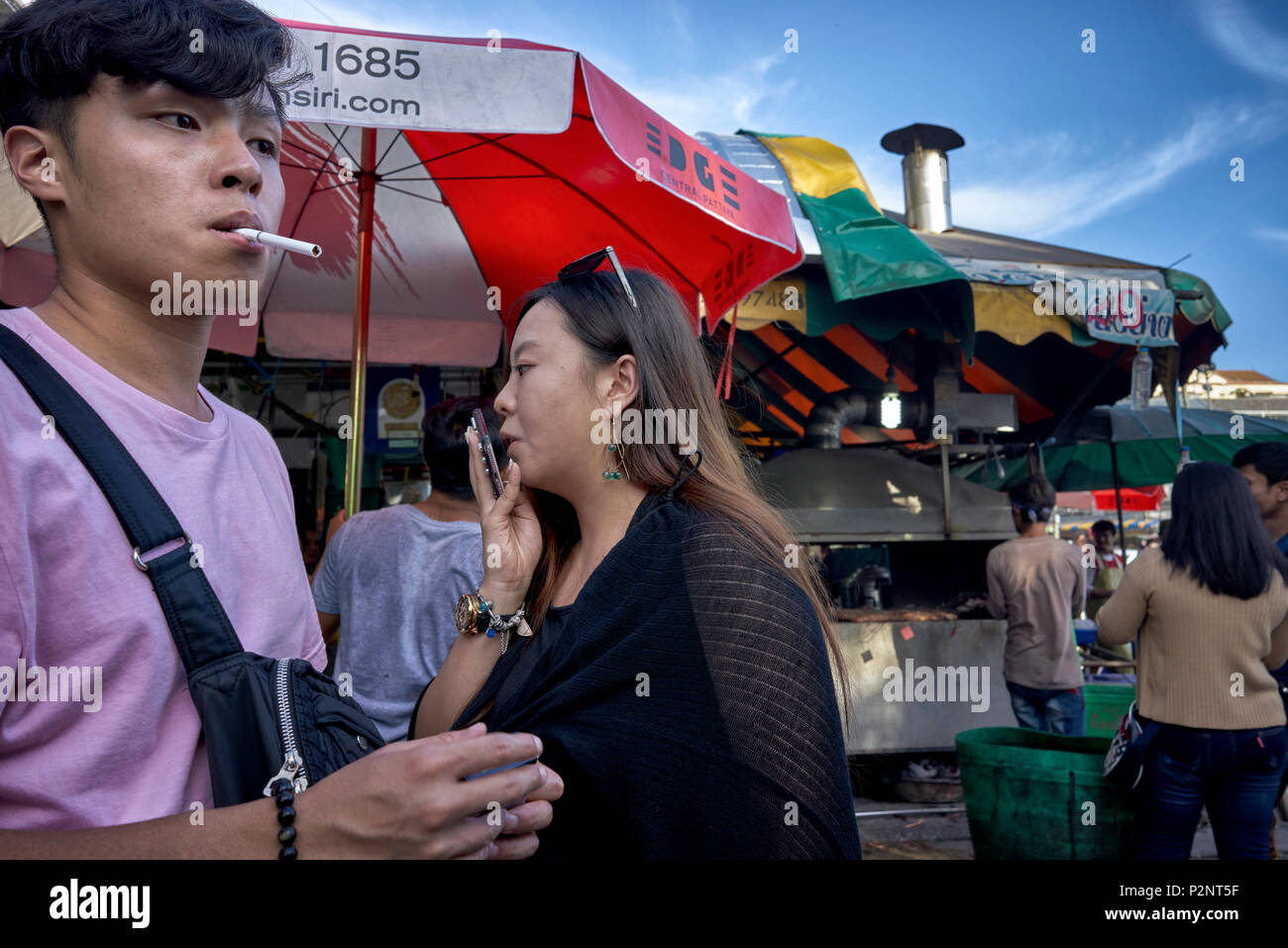 Cigarette Smoker, smokers, smoking cigarettes. outdoor Asian street