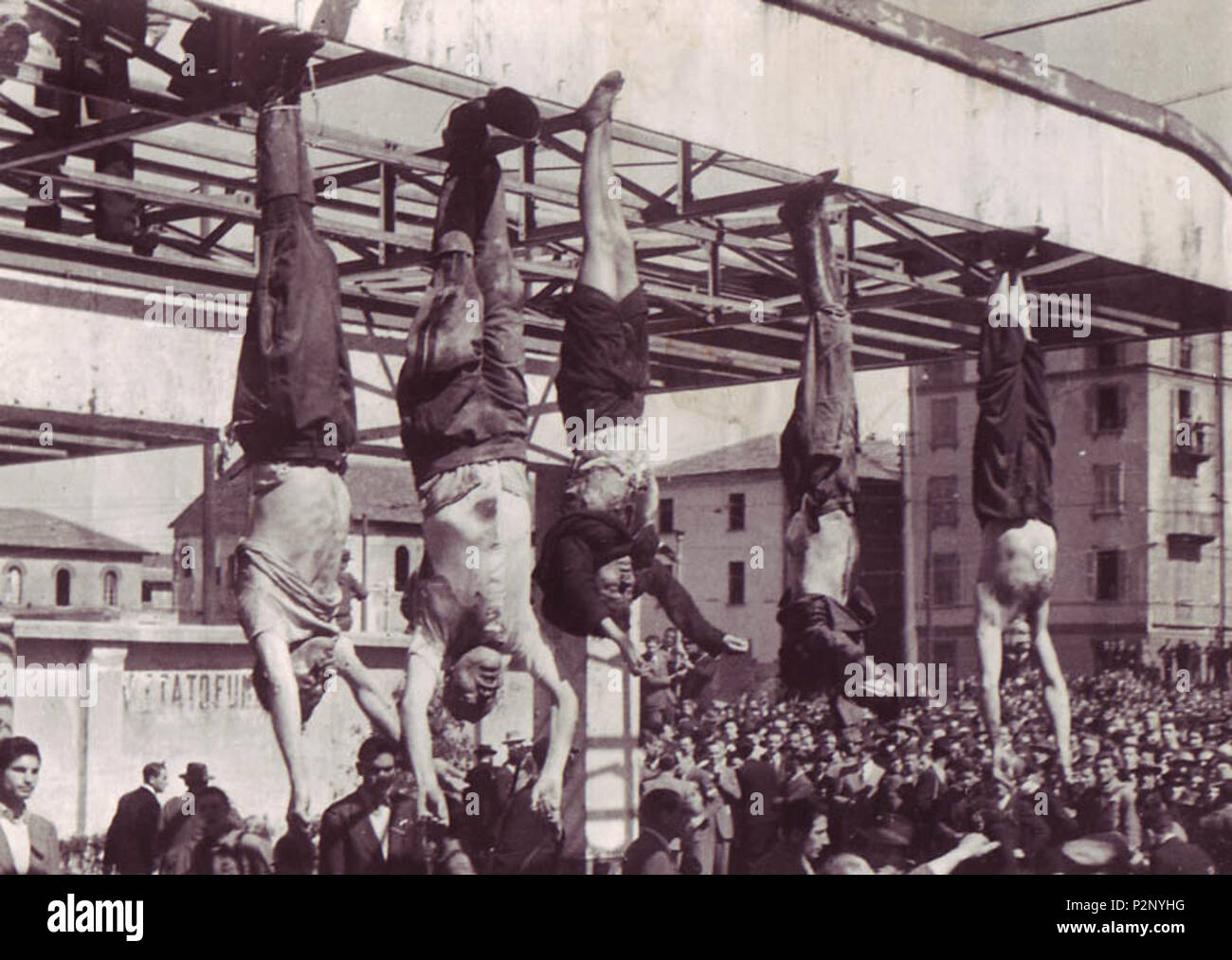 . English: The dead body of Benito Mussolini next to his mistress Claretta Petacci and those of other executed fascists, on display in Milan on 29 April 1945, in Piazzale Loreto, the same place that the fascists had displayed the bodies of fifteen Milanese civilians a year earlier after executing them in retaliation for resistance activity. The photograph is by Vincenzo Carrese. The bodies, from left to right, are: Nicola Bombacci Benito Mussolini Claretta Petacci Alessandro Pavolini Achille Starace  Deutsch: Die Leichen von Benito Mussolini, seiner Gefährtin Claretta Petacci und anderer fasch Stock Photo