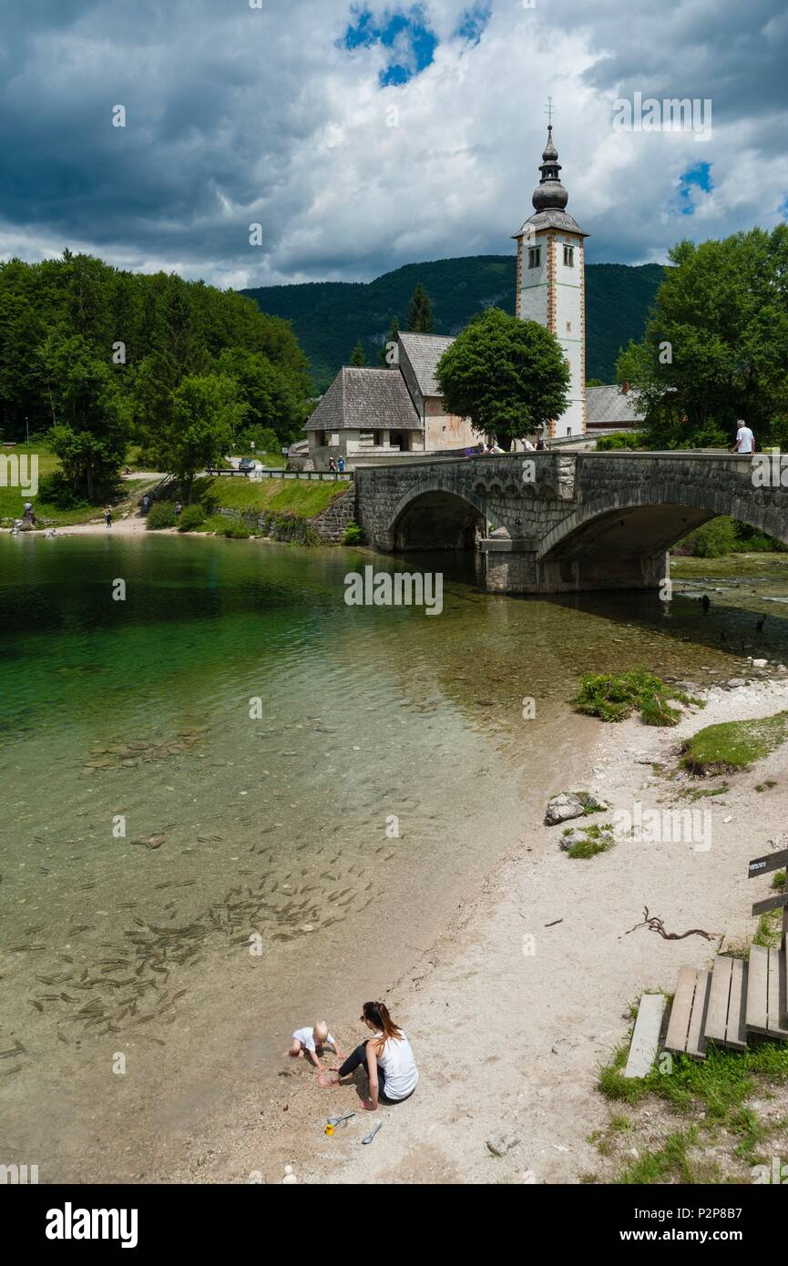The church of St John the Baptist and the stone bridge on lake Bohinj ...