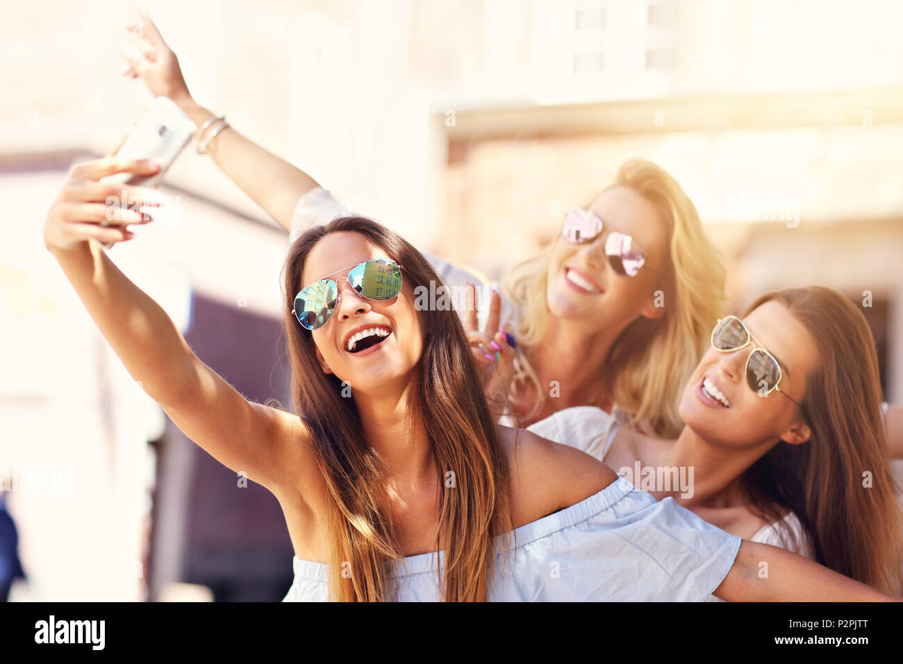 Happy girl friends hanging out in the city in summer Stock Photo