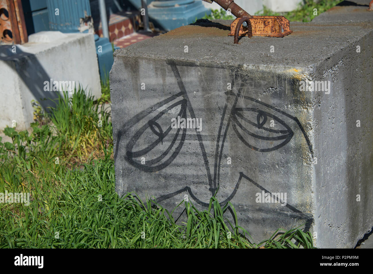 A concrete block has been given a face to observe the passerbys. Stock Photo