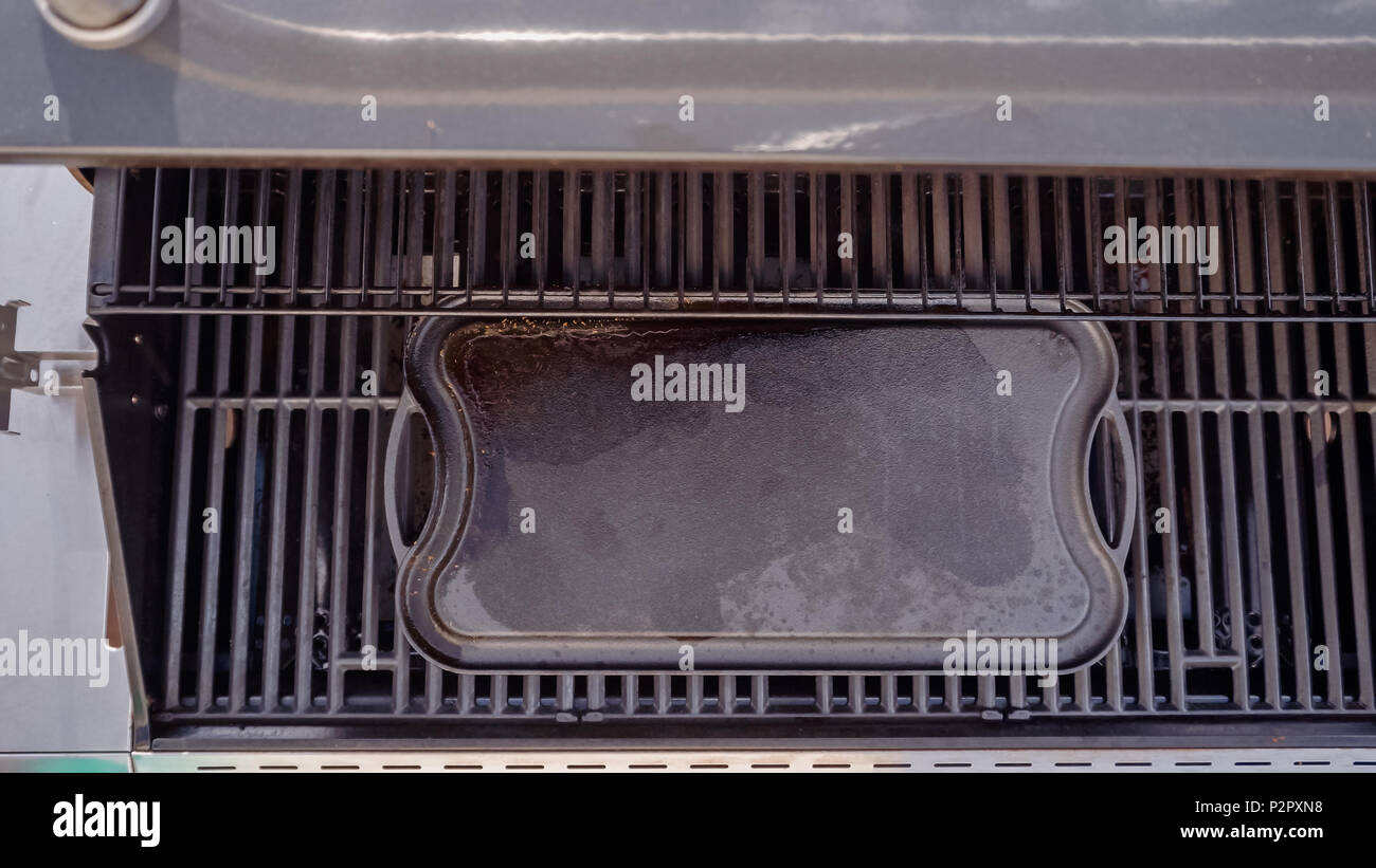 Empty cast iron griddle on outdoor gas grill Stock Photo Alamy
