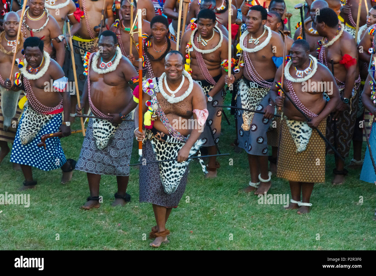 Swazi king (holding red scepter stick) and his warriors parade with girls at Umhlanga (Reed Dance Festival), Swaziland Stock Photo