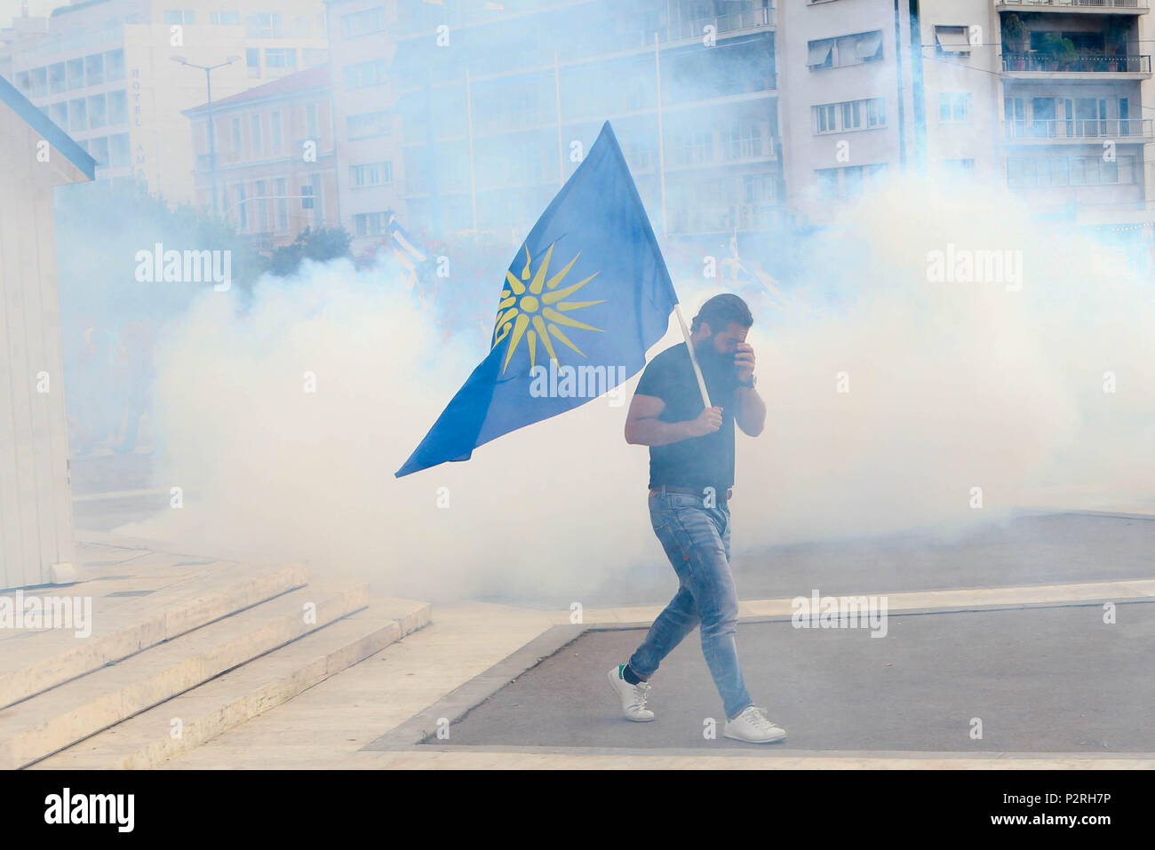 June 16, 2018 - Athens, Greece - Protester leave after riot police throw pepper spray during a protest against the agreement between Greece and Macedonia over the dispute of the former Yugoslav's republic name, outside the Greek Parliament, in Athens. Greek lawmakers on Saturday debated for a final day on a no-confidence motion against the government over a deal to end a decades-old dispute with neighboring Macedonia over the latter's name. (Credit Image: © Aristidis Vafeiadakis via ZUMA Wire) Stock Photo