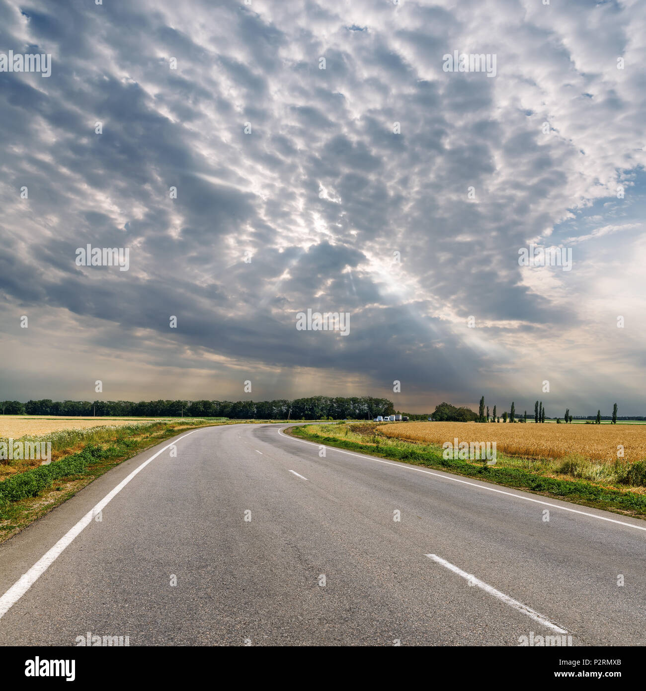 dramatic clouds over asphalt road to horizon Stock Photo - Alamy