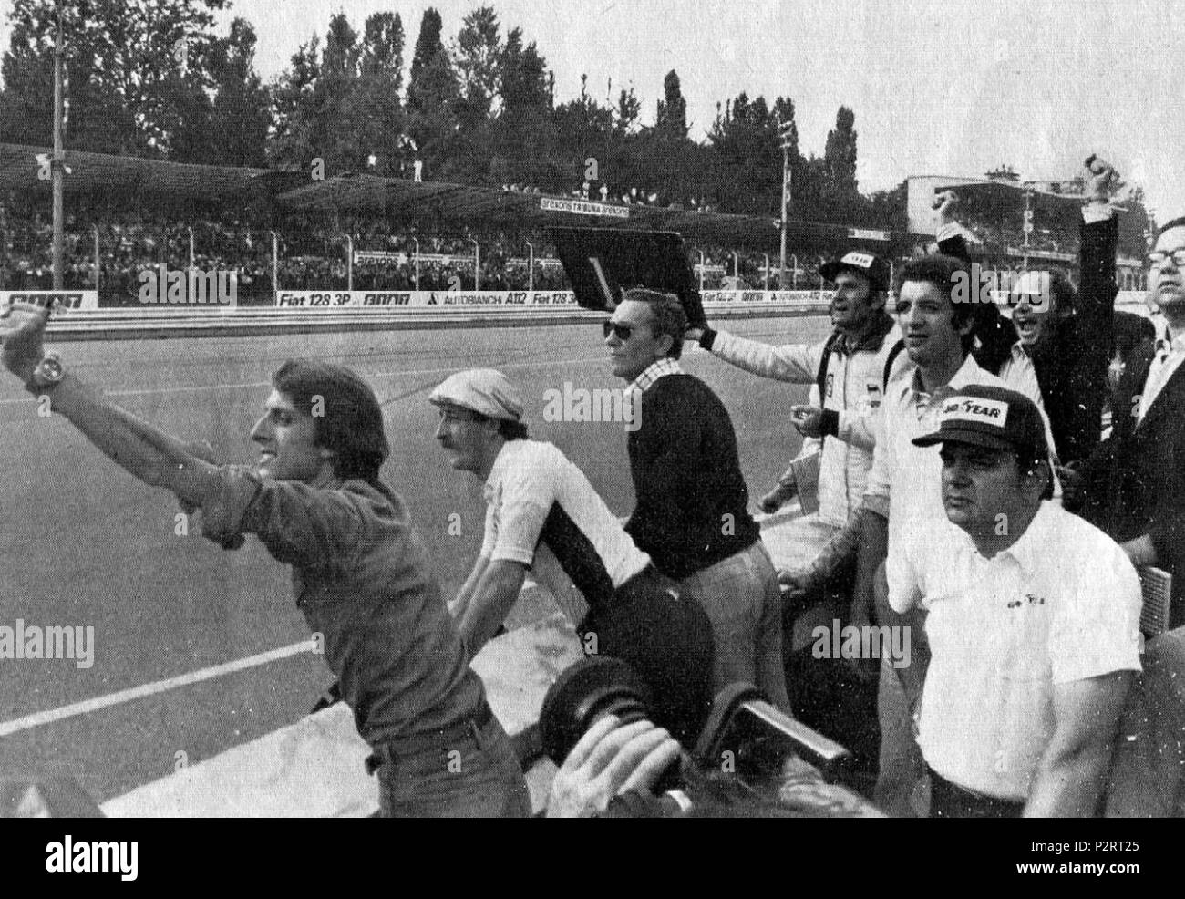 . Italiano: Monza, Autodromo Nazionale, 7 settembre 1975. XLVI Gran Premio d'Italia. Il box della Scuderia Ferrari, a pochi giri dal termine, incita dal muretto il suo pilota, lo svizzero Clay Regazzoni, in testa alla corsa; si riconosce (a sinistra) il team manager della scuderia, Luca Cordero di Montezemolo. “Cinquantesimo giro, Regazzoni sbuca dalla parabolica, ed i cartelli sono ormai superflui. Dal box Ferrari si alzano le braccia in segno di vittoria, il gesto di Luca Montezemolo è eloquente.” . 7 September 1975. Unknown 2 1975 Italian GP - Ferrari box rejoices Stock Photo