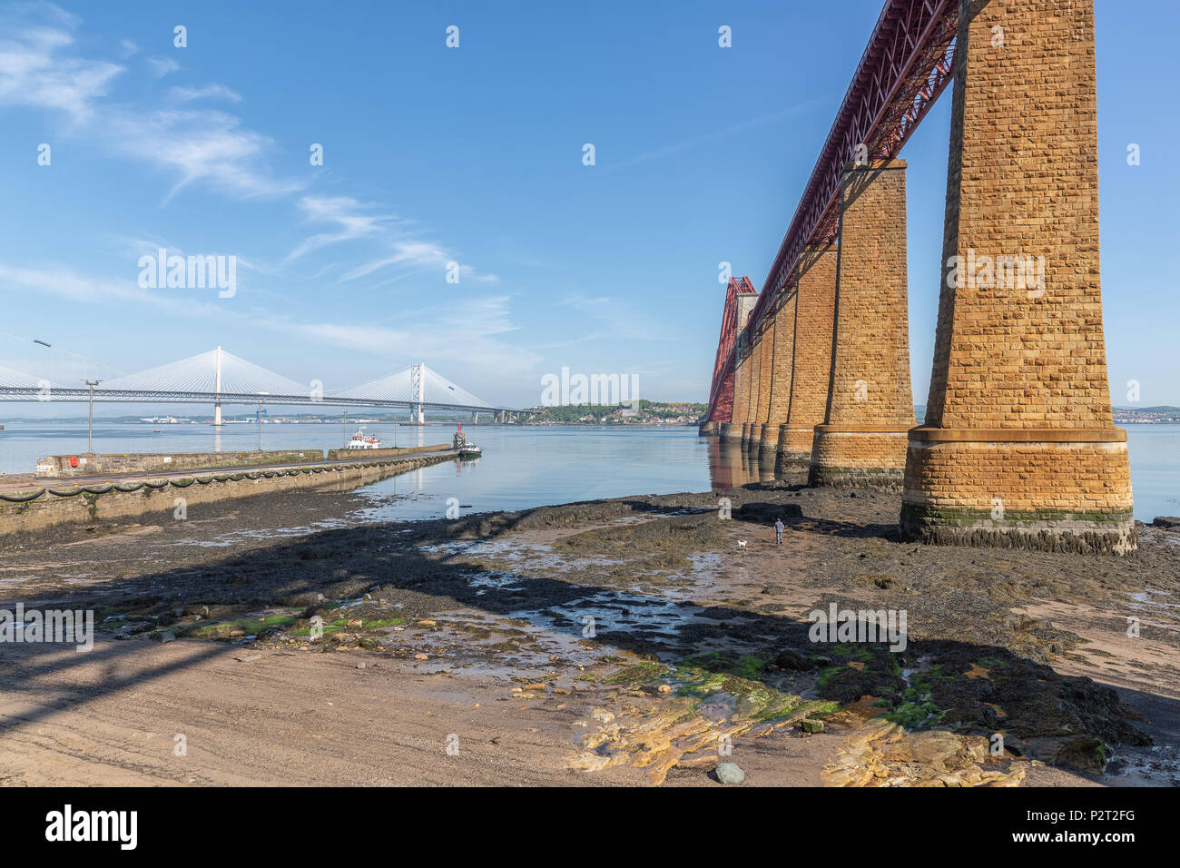 Forth Bridge Scotland and landing-stage for launches. In the background the Forth road bridge and Queensferry Crossing Bridge Stock Photo