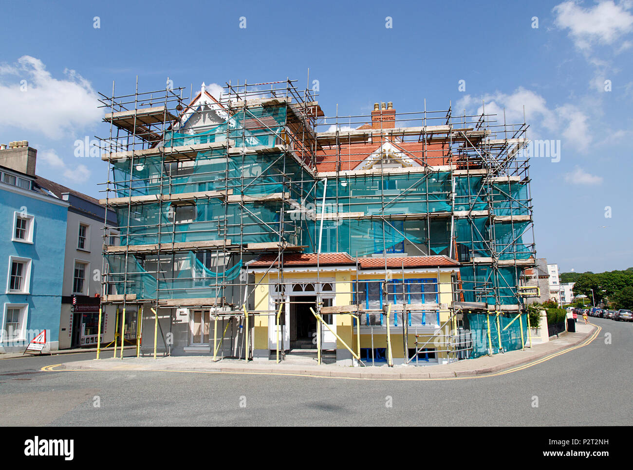 Tenby, UK: June 11, 2018: Large detached house undergoing complete renovation with scaffolding and protective netting. Stock Photo
