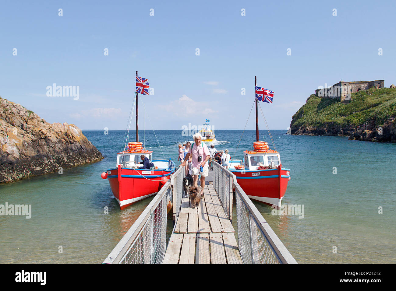 Tenby, UK: June 11, 2018: Tour boats moored at the pontoon in Tenby ready to sail to Caldey Island. Passengers disembark after visiting Holy Island. Stock Photo