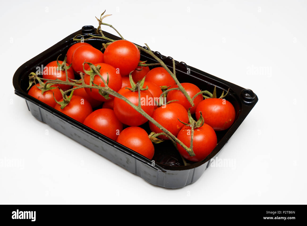 a plastic tray with some tomatoes Stock Photo