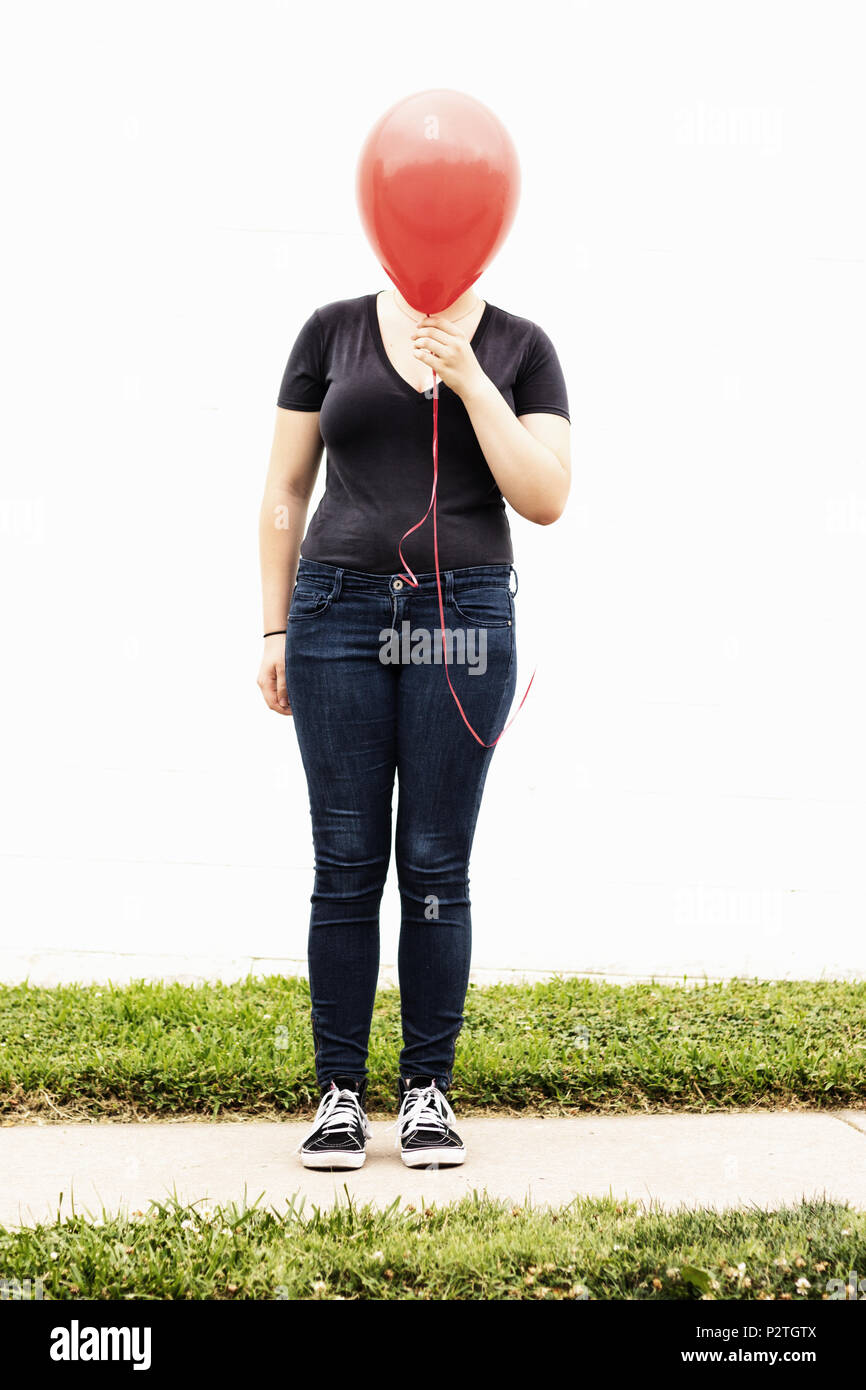 red balloon covering girls face Stock Photo