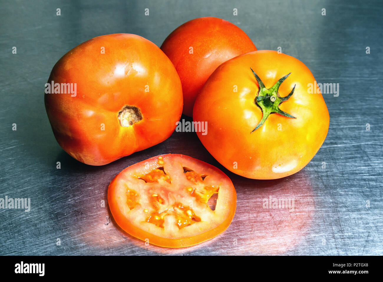 tomatoes and slice on stainless steel background Stock Photo