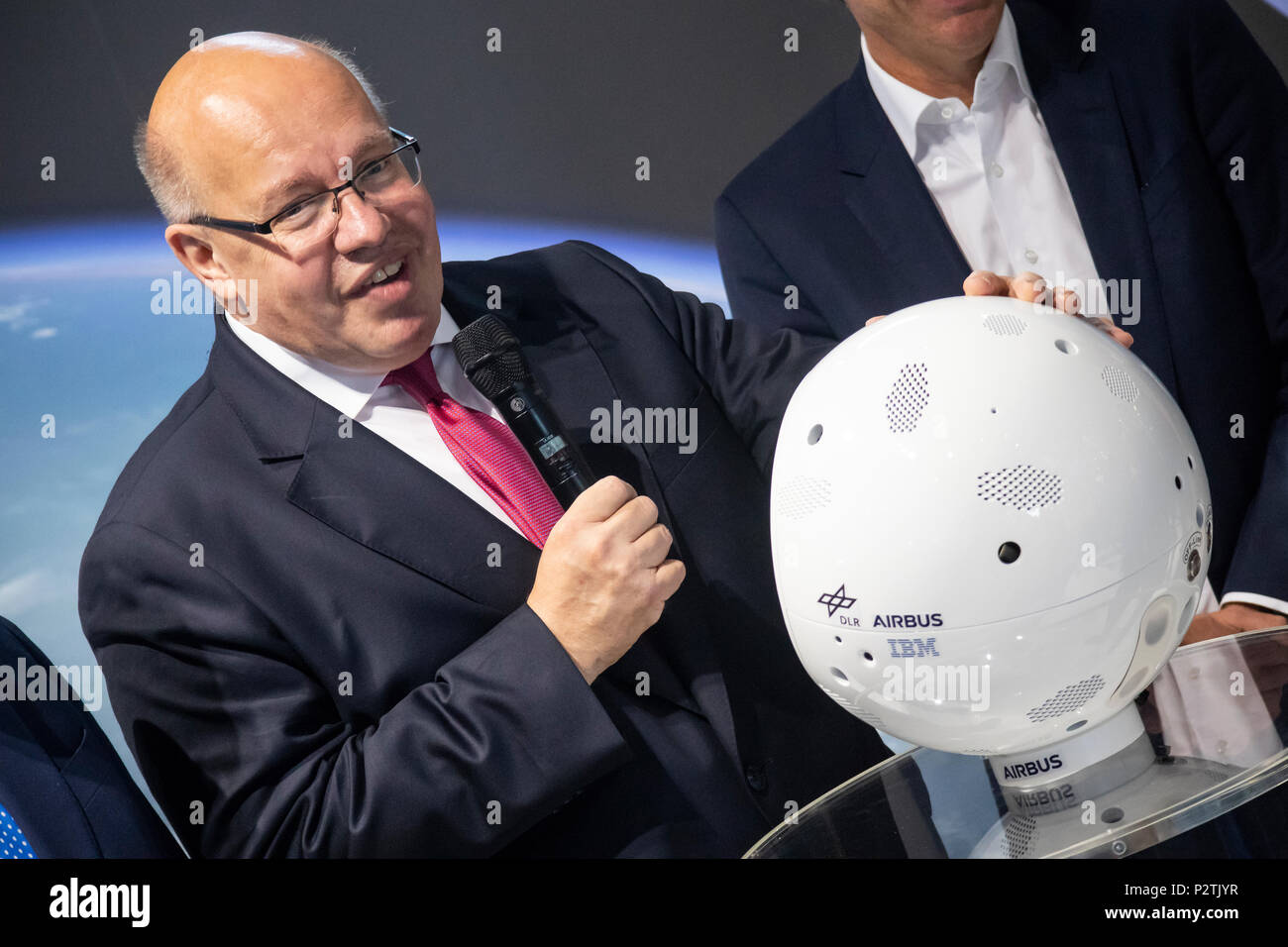 Hannover, Germany. 12th June, 2018. IT-expo CEBIT 2018 opening walk with Peter Altmaier, Federal Minister for Economic Affairs and Energy Germany. Here at IBM booth, presenting robot CIMON (Crew Interactive Mobile CompaniON), an intelligent, mobile and interactive astronaut assistance system, developed by Airbus on behalf of German Aerospace Center (DLR), using IBM Watson technology, tested on ISS as part of Horizons mission of European Space Agency (ESA). Credit: Christian Lademann Stock Photo