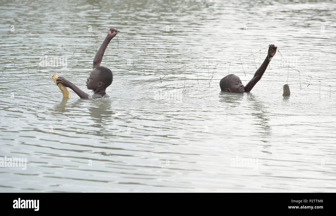 Manyok Garang (left), 11, and Choul Majak, 9, catch fish in Poktap, a town in South Sudan's war-torn Jonglei State. Stock Photo
