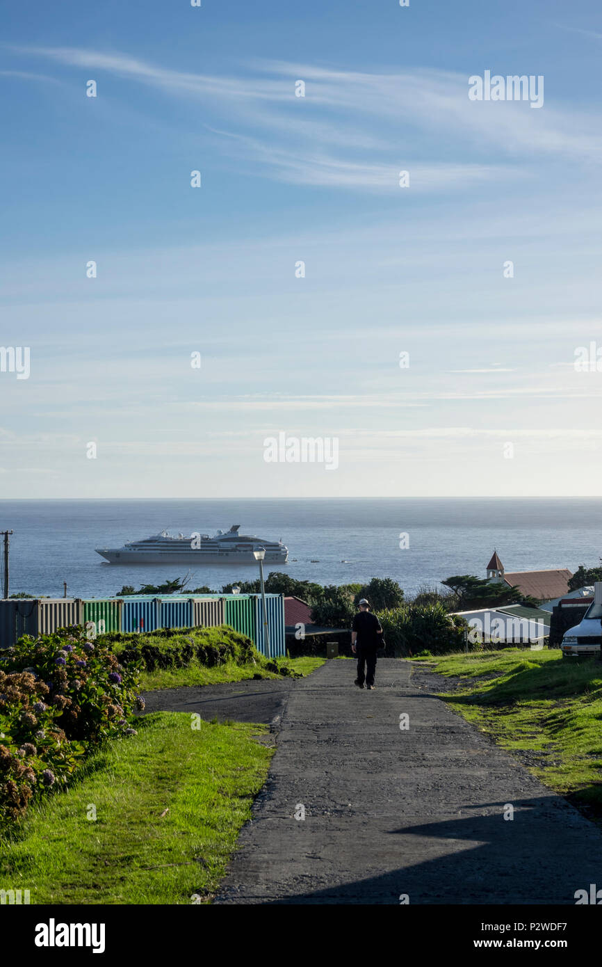 Man walking down path with Le Lyrial in the background at Tristan da Cunha, British Overseas Territories, South Atlantic Ocean Stock Photo