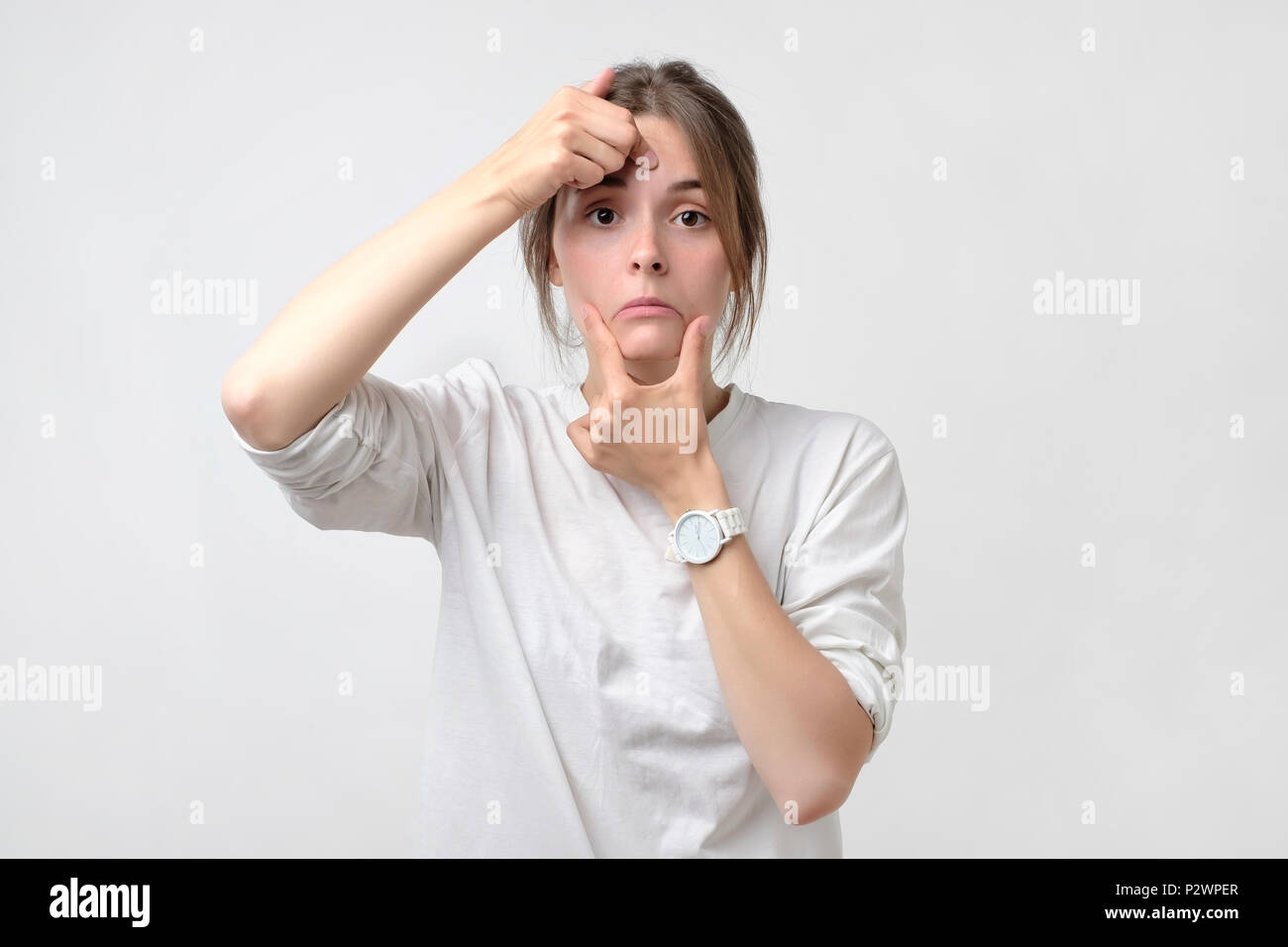 Pretty caucasian woman pulling a smile on her face. Concept of loss of work or being alone. Bad facial emotion because of depression Stock Photo
