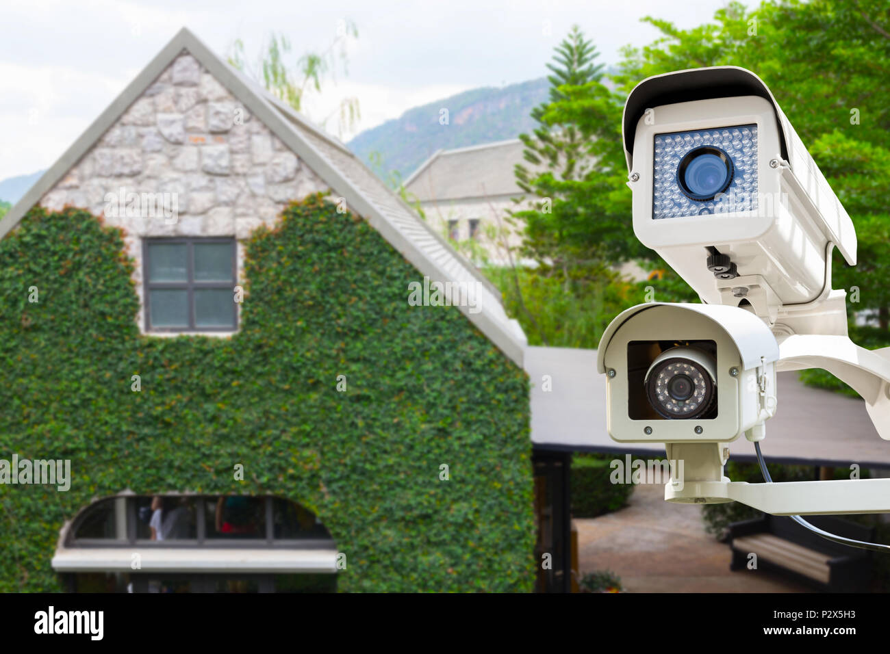 The CCTV security camera operating on luxury roof house blur background