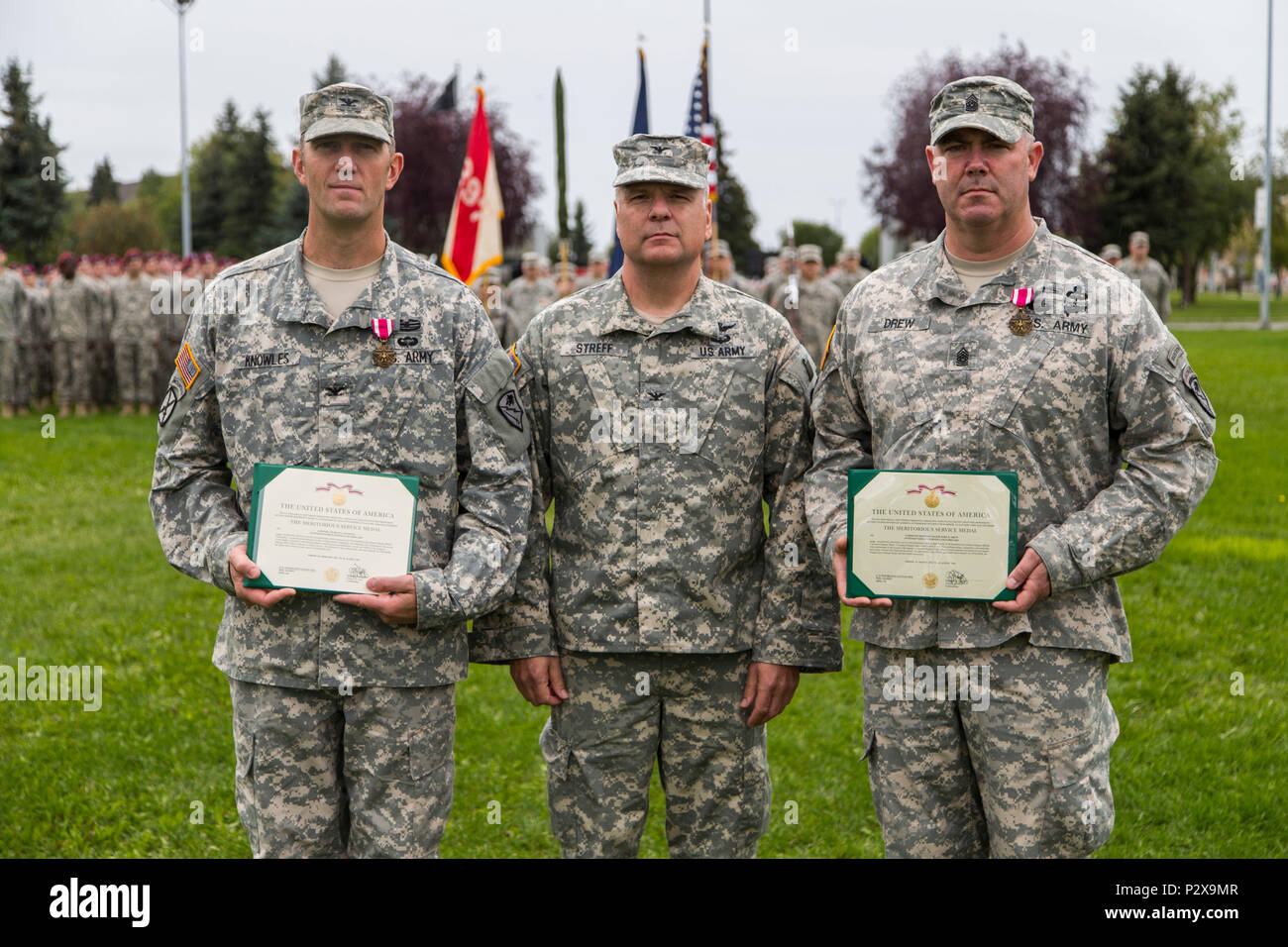 Col. Joseph Streff, center, Alaska Army National Guard commander, stands for a picture after presenting meritorious service medals to Col. Lee Knowles, left, 297th Battlefield Surveillance Brigade commander, and Command Sgt. Maj. John Drew, 297th BFSB sergeant major, during a ceremonial deactivation of the 297th BFSB and activation of the 297th Regional Support Group at the Delaney Park Strip located in downtown Anchorage, Aug. 6, 2016. The 297th RSG will officially transition Sept. 1. (U.S. Army national Guard photo by Spc. Mike Risinger) Stock Photo