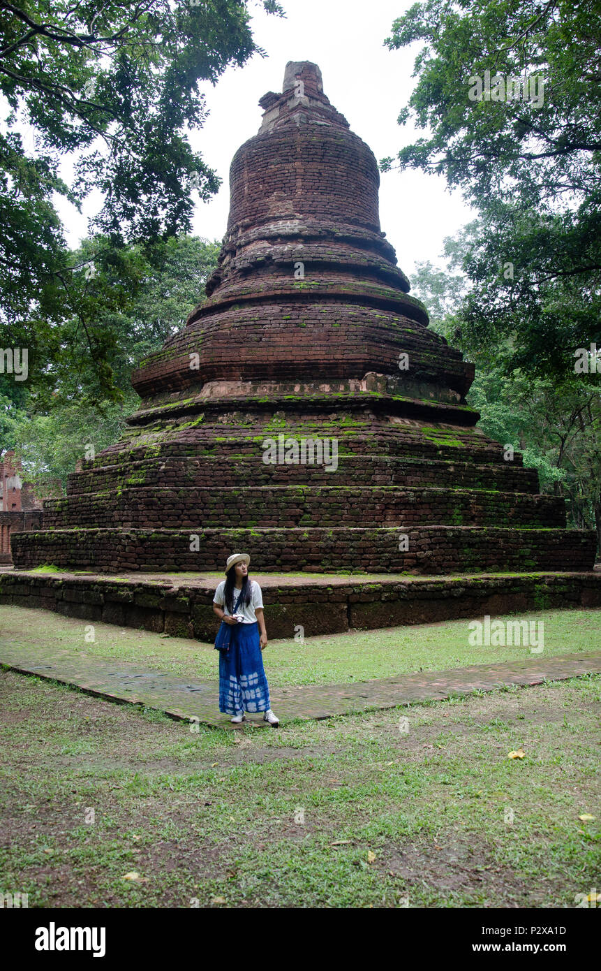Travelers thai woman walking visit and travel take photo in ancient building and ruins of Kamphaeng Phet Historical Park is an archeological site and  Stock Photo