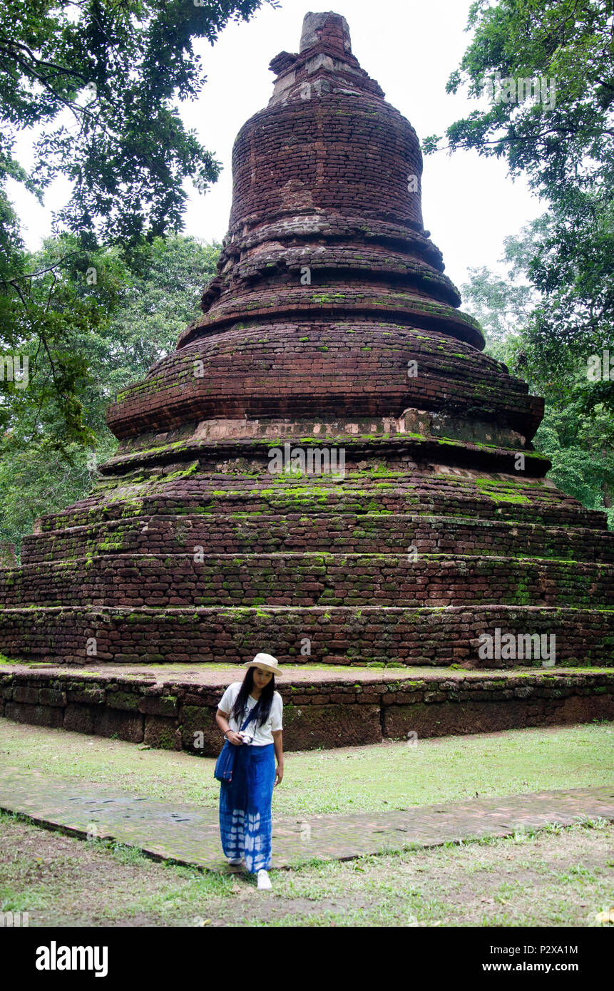 Travelers thai woman walking visit and travel take photo in ancient building and ruins of Kamphaeng Phet Historical Park is an archeological site and  Stock Photo