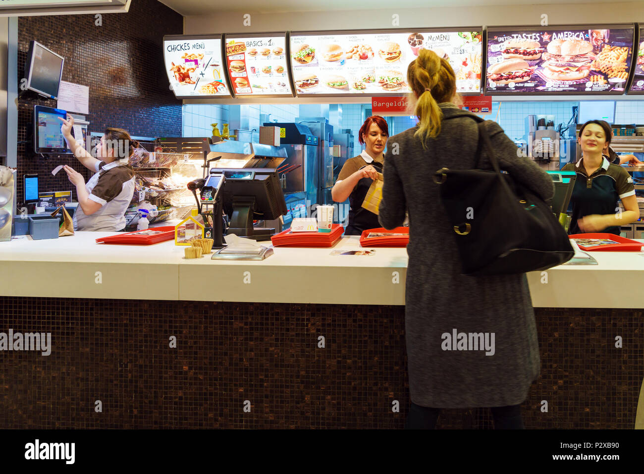 Munich, Germany - October 24, 2017: The girl receives an order in the interior of the McDonald's fast-food restaurant Stock Photo