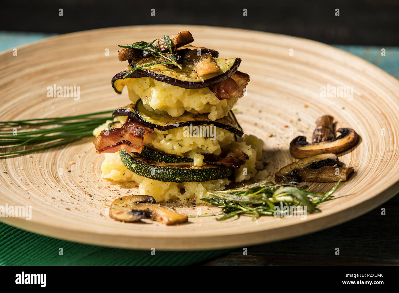 Schichtturm mit Stampfkartoffeln, Auberginen, Zucchini und Champignons und Bacon, Studio Stock Photo