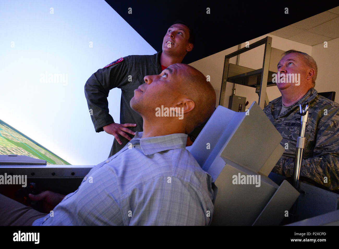 U.S. Sen. Cory Booker, center, looks up at a target in an F-16 simulator while U.S. Air Force 1st Lt. Nicholas Loglisci, fighter pilot, and Brig. Gen. Michael L. Cunniff, the Adjutant General of the New Jersey National Guard, right, observe at the 177th Fighter Wing in Egg Harbor Township, N.J. on Aug. 5, 2016. During  Sen. Booker's first visit to the 177th FW, he also received a briefing by the Wing Commander, U.S. Air Force Col. John R. DiDonna, and got a chance to get an up close look at an F-16C Fighting Falcon fighter jet on the flight line at the Atlantic City Air National Guard base. (U Stock Photo