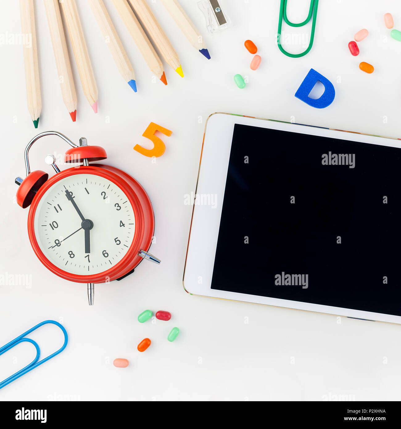 Square flat lay back to school concept blank tablet with alarm clock ...