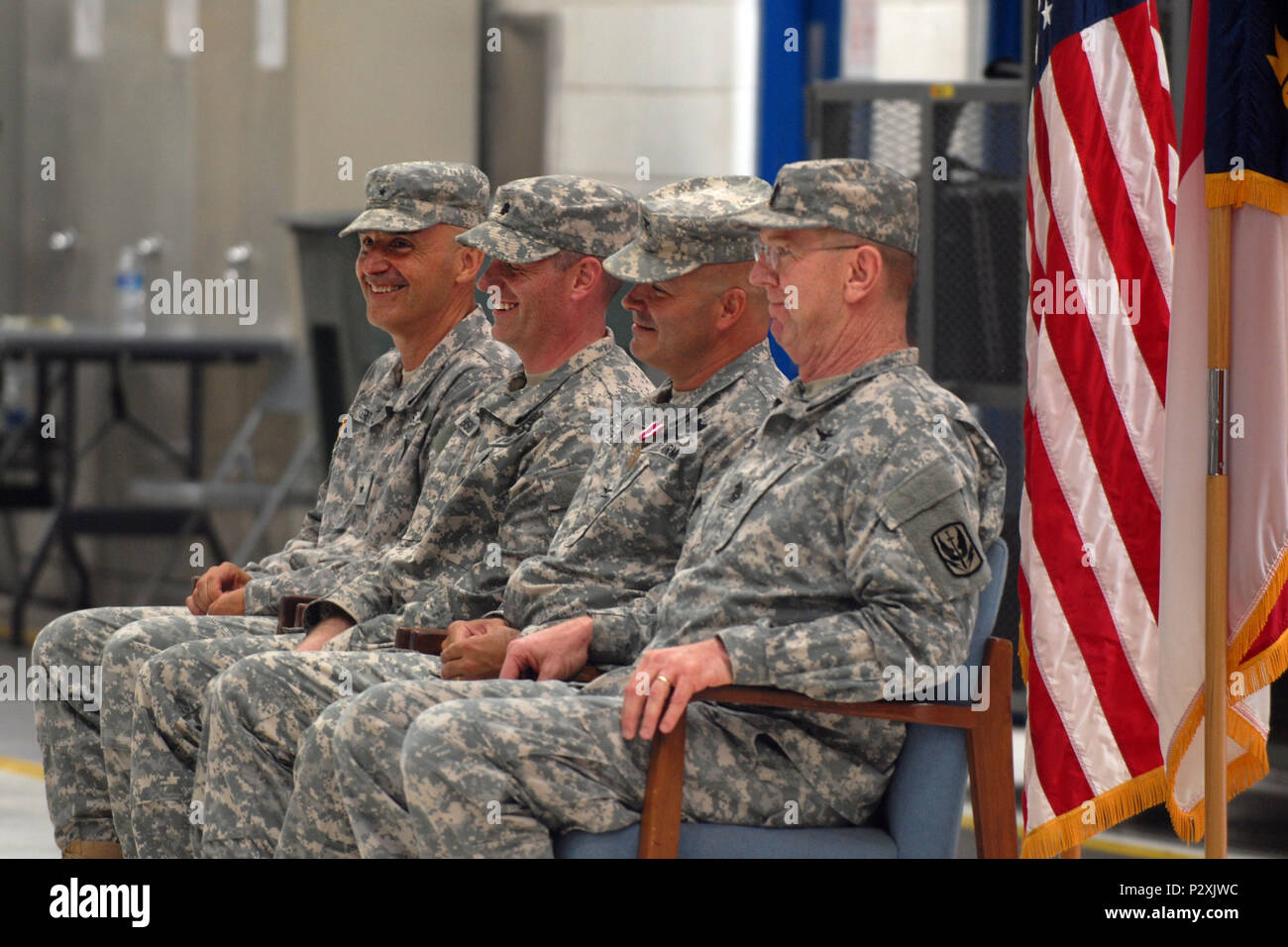 Brig. Gen. James C. Ernst, Lt. Col. Joseph W. Bishop, Col. Jeffrey L. Copeland and Command Sgt. Maj. Derwood L. Norris sit in the seats of honor during the change of command ceremony at the North Carolina Army National Guard's Army Aviation Support Facility 1 in Morrisville, N.C., on August 7, 2016. Bishop, who served previously as the commander of 1-130th Attack Reconnaissance Battalion, became commander of 449th Theater Aviation Brigade and Copeland has been promoted to Chief of Staff for the North Carolina Army National Guard. (U.S. Army National Guard photo by Staff Sgt. Meiling Gray, 449t Stock Photo