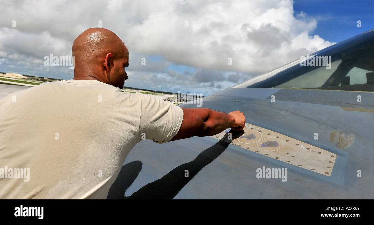 U.S. Air Force Senior Airman Julian Tobin, an aerospace repair technician with the 509th Maintenance Squadron, tapes off sections of a B-2 Spirit from Whiteman Air Force Base, Mo., Aug. 10, 216 at Andersen Air Force Base, Guam. The U.S. routinely and visibly demonstrates its commitment to its allies and partners through the global operations of our military forces. (U.S. Air Force photo by Senior Airman Jovan Banks) Stock Photo
