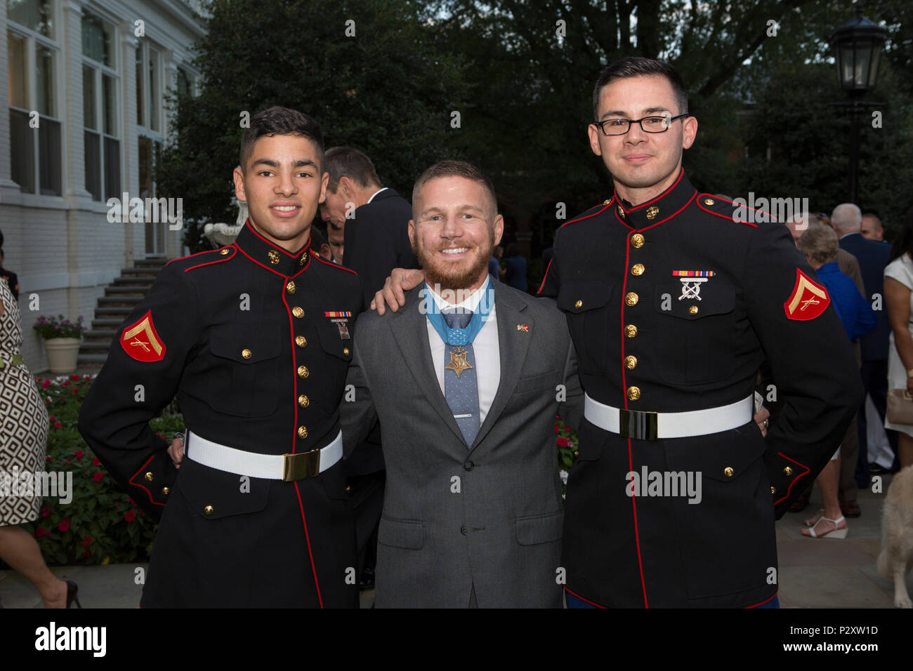 Retired U.S. Marine Corps Cpl. William Kyle Carpenter, Medal of Honor recipient, poses for a photo with Lance Cpl. Bryce Alvarez, right, and Lance Cpl Alex Gonzolez, left, Headquarters and Service Battallion, Marine Corps Base Henderson Hall, during the evening parade reception in the Marine Family Garden, Marine Barracks Washington, Washington, D.C., Aug. 5, 2016. Evening parades are held as a means of honoring senior officials, distinguished citizens and supporters of the Marine Corps. (U.S. Marine Corps photo by Cpl. Christian J. Varney) Stock Photo