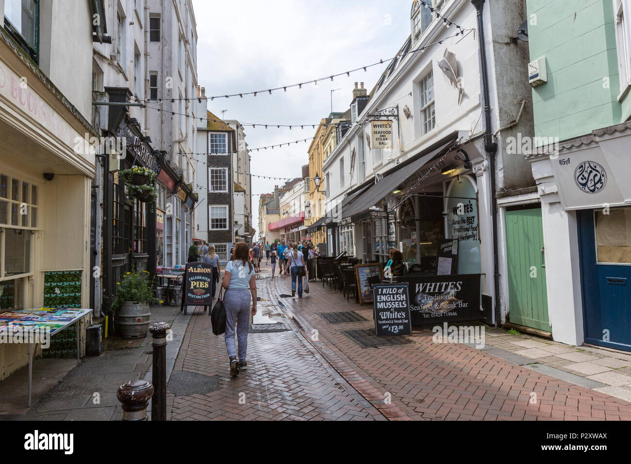 People walking along street at Hastings old town, East Sussex