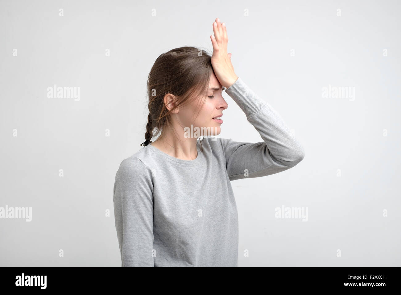young stressed caucasian woman touching her forehead in pain. Memory