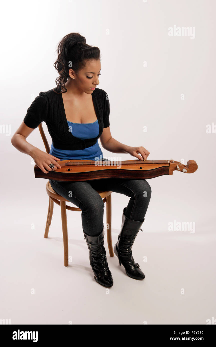 4 string Appalachian mountain Dulcimer being played in the traditional manner using a short piece of dowel on the melody string Stock Photo