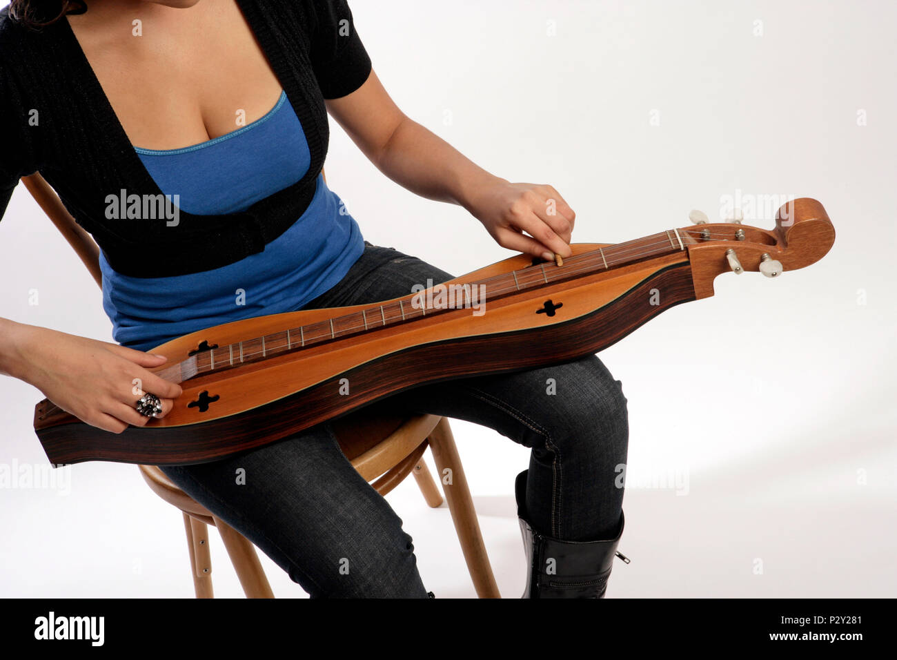4 string Appalachian Mountain Dulcimer being played in the traditional manner using a short piece of dowel to stop the string Stock Photo