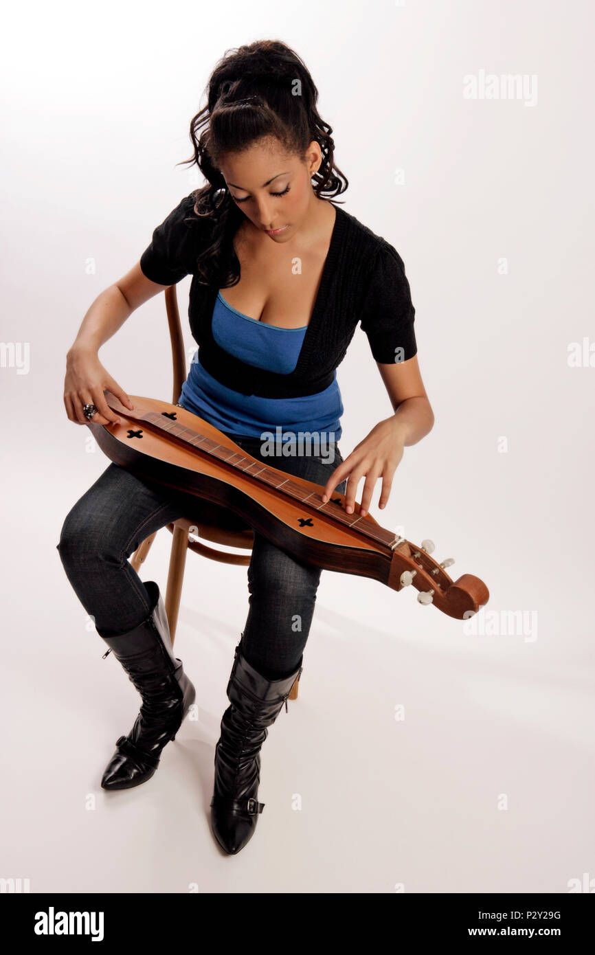 Young woman playing a 4 string Appalchian or Mountain Dulcimer Stock Photo