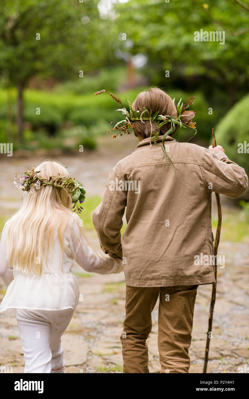 Cute brother and sister in rural chic forest fashion clothing walking ...