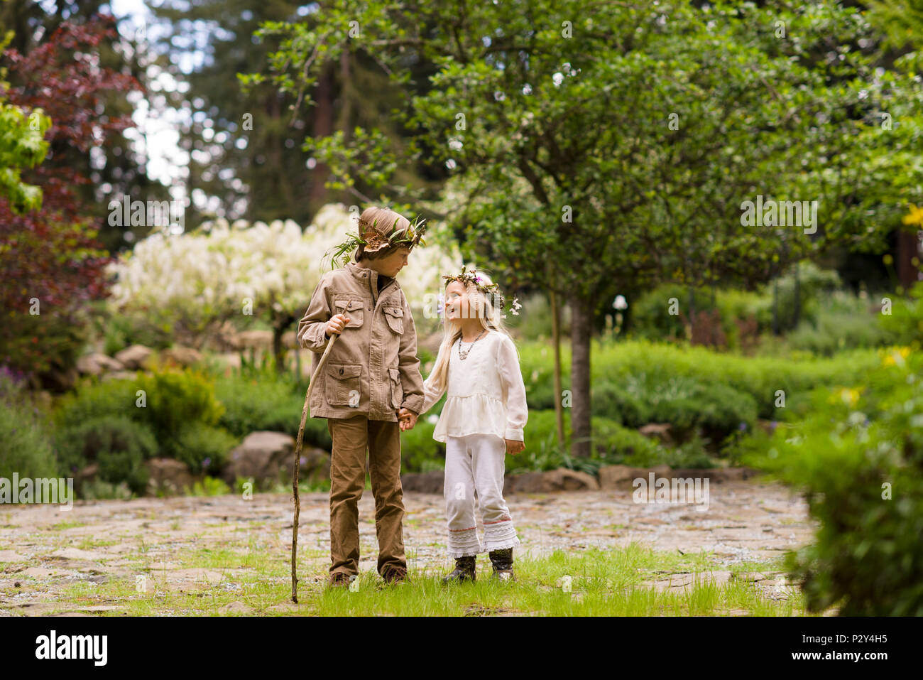Cute brother and sister in rural chic forest fashion clothing walking ...