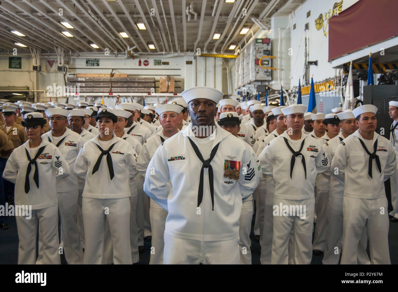 160804-N-EW322-033 SAN DIEGO (Aug. 4, 2016) – Aviation Structural Mechanic 1st Class Jamaan Fripp, from Beaufort, South Carolina, stands in formation with fellow USS Makin Island (LHD 8) Sailors during a change of command ceremony in the ship’s hangar bay. Capt. Mark Melson relieved Capt. Jon P. Rodgers during the ceremony. The amphibious assault ship is homeported in San Diego. (U.S. Navy photo by Mass Communication Specialist Seaman Clark D. Lane/Released) Stock Photo