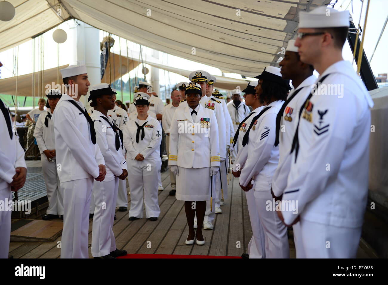 160806-N-DD899-200 BALTIMORE, Md. (Aug. 8, 2016) Cmdr. Tasya Lacy, center, prepares to pass through ceremonial sideboys as part of the official party for the Navy Operational Support Center (NOSC) Batimore change of command ceremony aboard USS Constellation in Baltimore Inner Harbor. Lacy relieved Cmdr. John B. Downes as the NOSC Baltimore commanding officer. (U.S. Navy photo by Mass Communication Specialist 1st Class Sharay Bennett/Released) Stock Photo