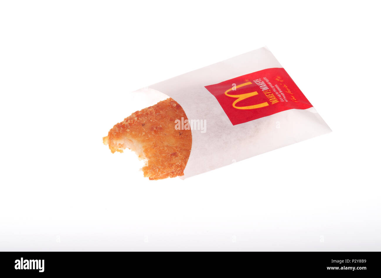 McDonald’s Hash Brown potato with bite taken out isolated on white background Stock Photo