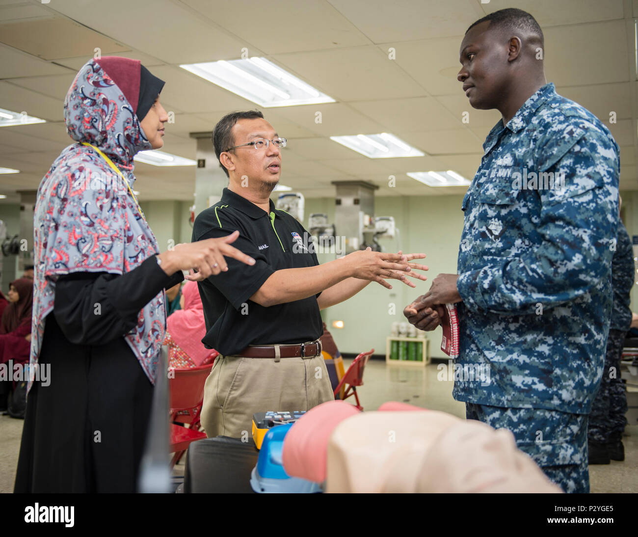 160809-N-QW941-060 KUANTAN, Malaysia (Aug. 9, 2016) Hospital Corpsman 2nd Class Harrison Mwanzi (right), a native of San Diego, assigned to hospital ship USNS Mercy (T-AH 19), speaks with Malaysian doctors prior to a Pacific Partnership 2016 advanced cardiovascular life support training course aboard Mercy. During the training, Pacific Partnership 2016 personnel and Malaysian doctors discussed guidelines for treating patients with cardiac arrest and other life threatening emergencies. This is the first time Mercy and Pacific Partnership have visited Malaysia. During the mission stop partner na Stock Photo
