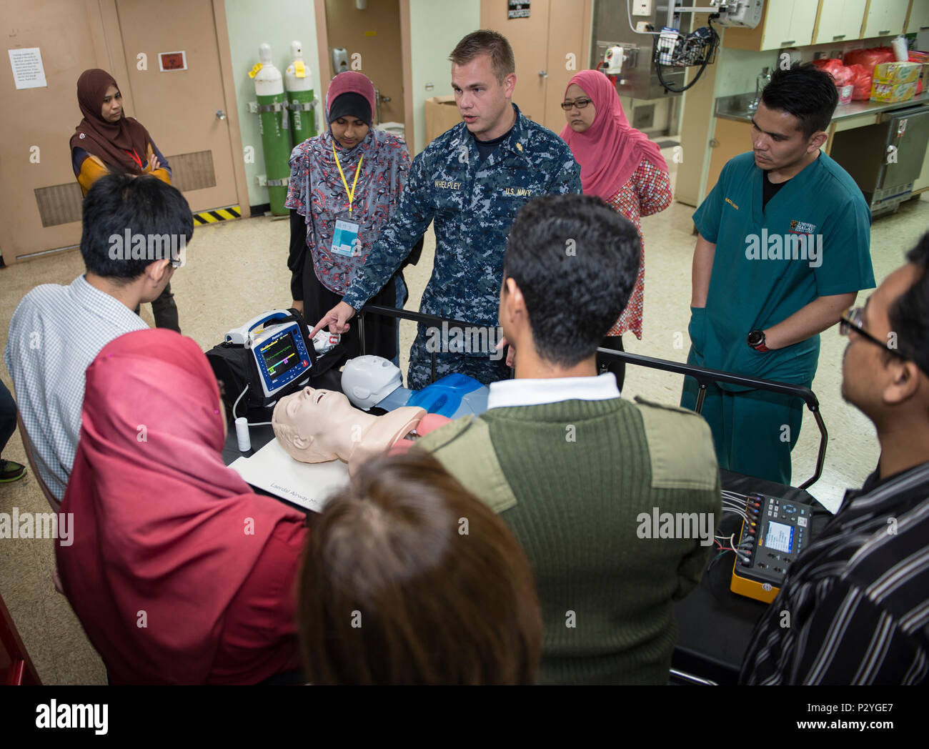 160809-N-QW941-076 KUANTAN, Malaysia (Aug. 9, 2016) Lt. Steven Whelpley (center), a native of Fredericksburg, Virginia and an emergency physician assigned to hospital ship USNS Mercy (T-AH 19), reviews defibrillator operations during a Pacific Partnership 2016 advanced cardiovascular life support training course aboard Mercy. During the training, Pacific Partnership 2016 personnel and Malaysian doctors discussed guidelines for treating patients with cardiac arrest and other life threatening emergencies. This is the first time Mercy and Pacific Partnership have visited Malaysia. During the miss Stock Photo