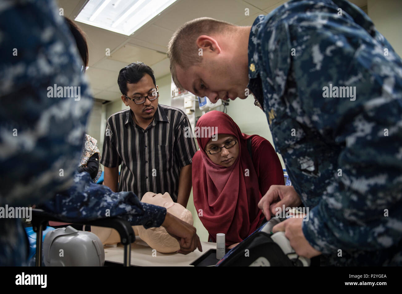 160809-N-QW941-084 KUANTAN, Malaysia (Aug. 9, 2016) Lt. Steven Whelpley (right), a native of Fredericksburg, Virginia and an emergency physician assigned to hospital ship USNS Mercy (T-AH 19), reviews defibrillator operations during a Pacific Partnership 2016 advanced cardiovascular life support training course aboard Mercy. During the training, Pacific Partnership 2016 personnel and Malaysian doctors discussed guidelines for treating patients with cardiac arrest and other life threatening emergencies. This is the first time Mercy and Pacific Partnership have visited Malaysia. During the missi Stock Photo