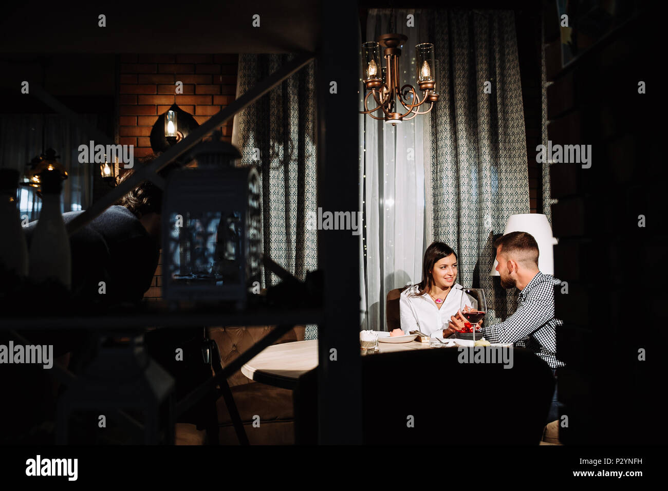 Young happy couple romantic date drink glass of red wine at restaurant ...